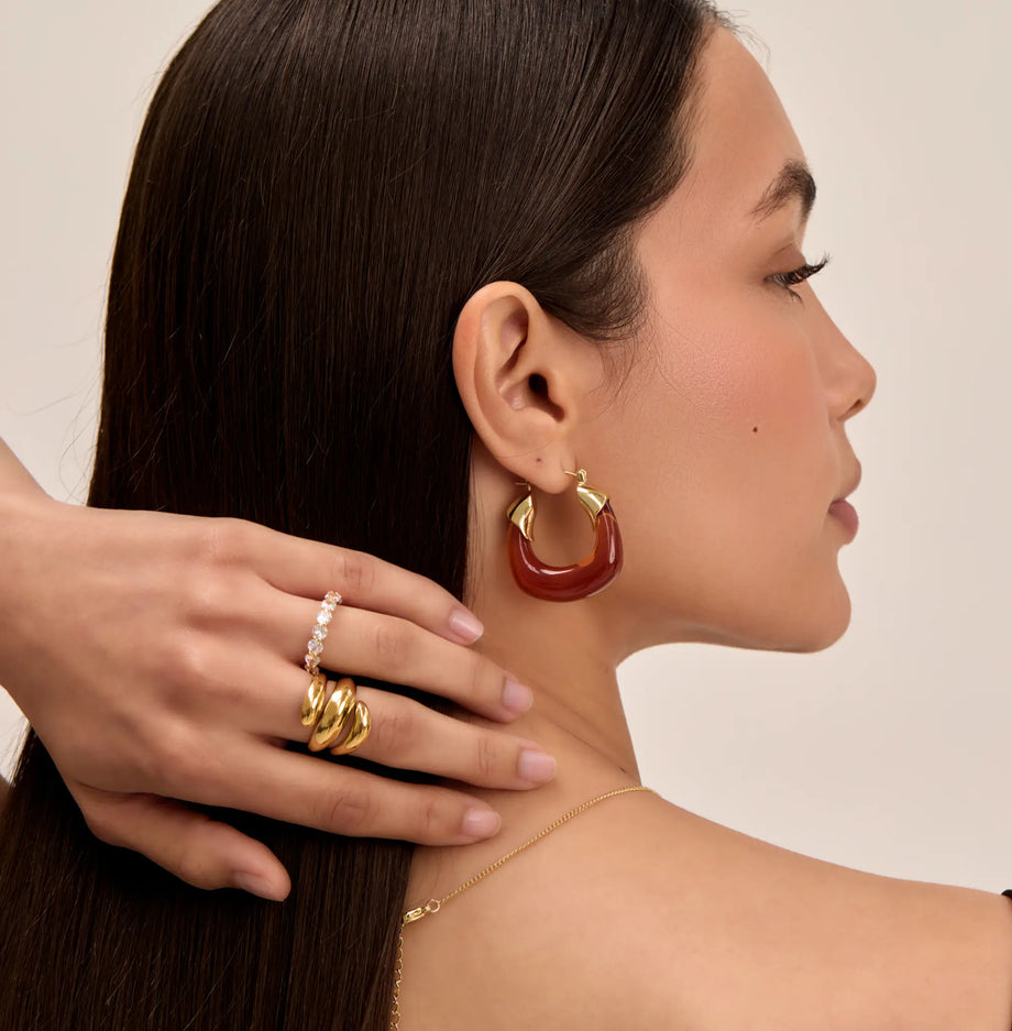 model wearing amber celine earrings in gold and chunky gold rings from prya