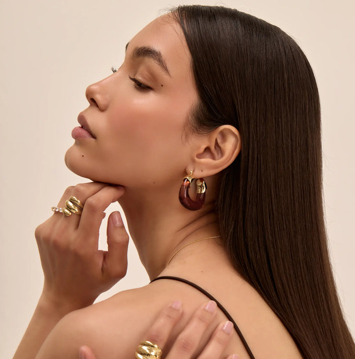 model wearing amber celine earrings in gold and chunky gold rings from prya