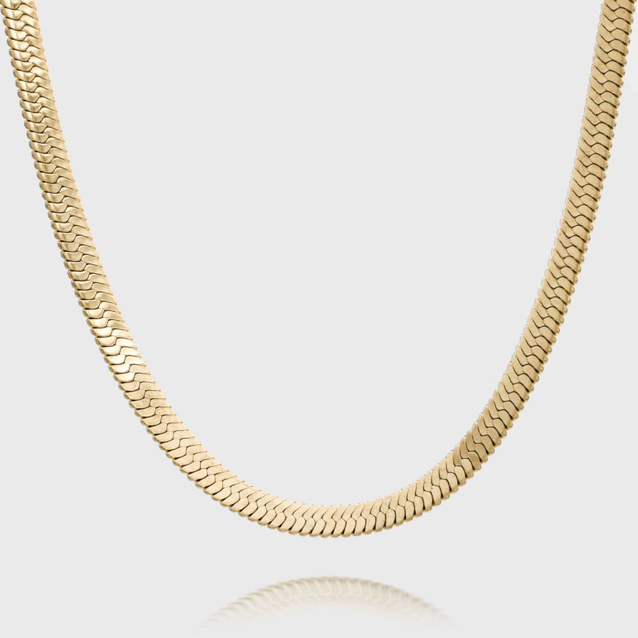 Gold chunky snake chain necklace on white background.