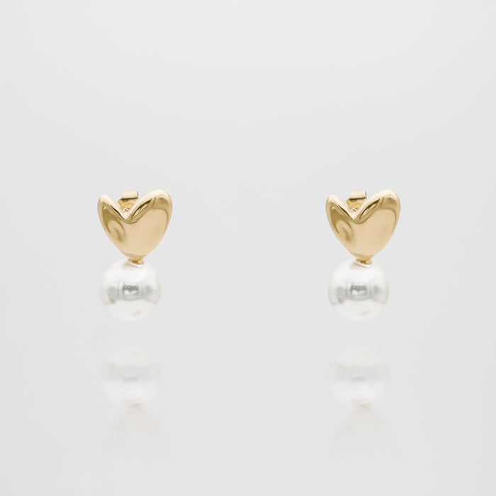 Gold heart-shaped earrings with dangling pearls.