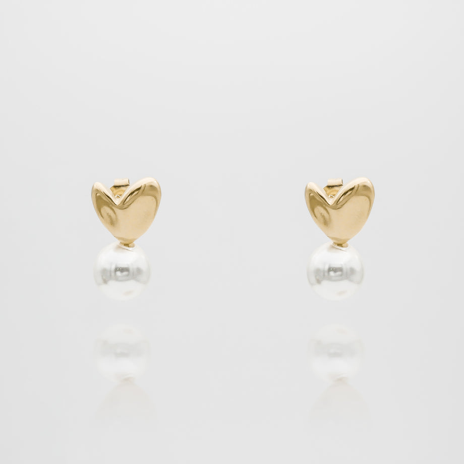 Gold heart-shaped earrings with dangling pearls.