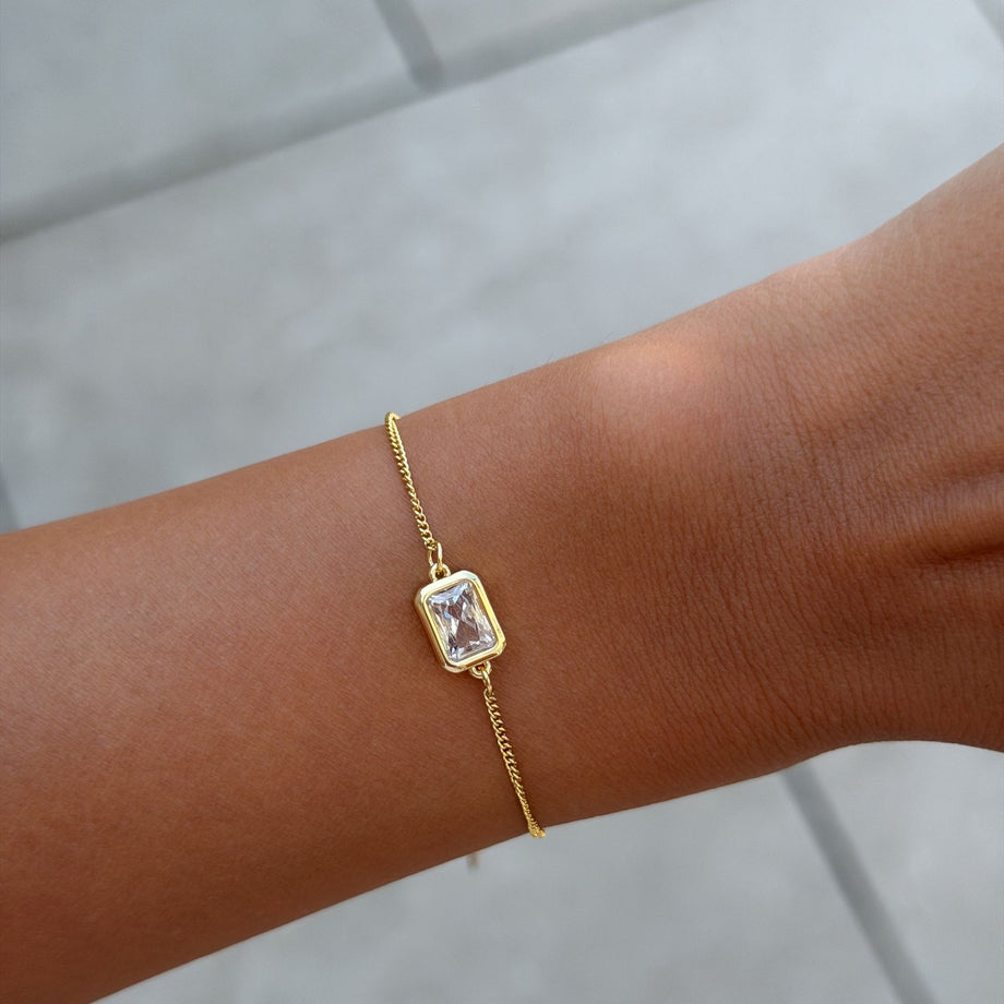 Model wearing the april emerald cut birthstone bracelet  in gold from prya