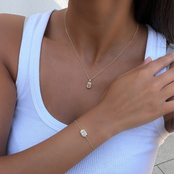Model wearing the april emerald cut birthstone necklace and bracelet  in gold from prya