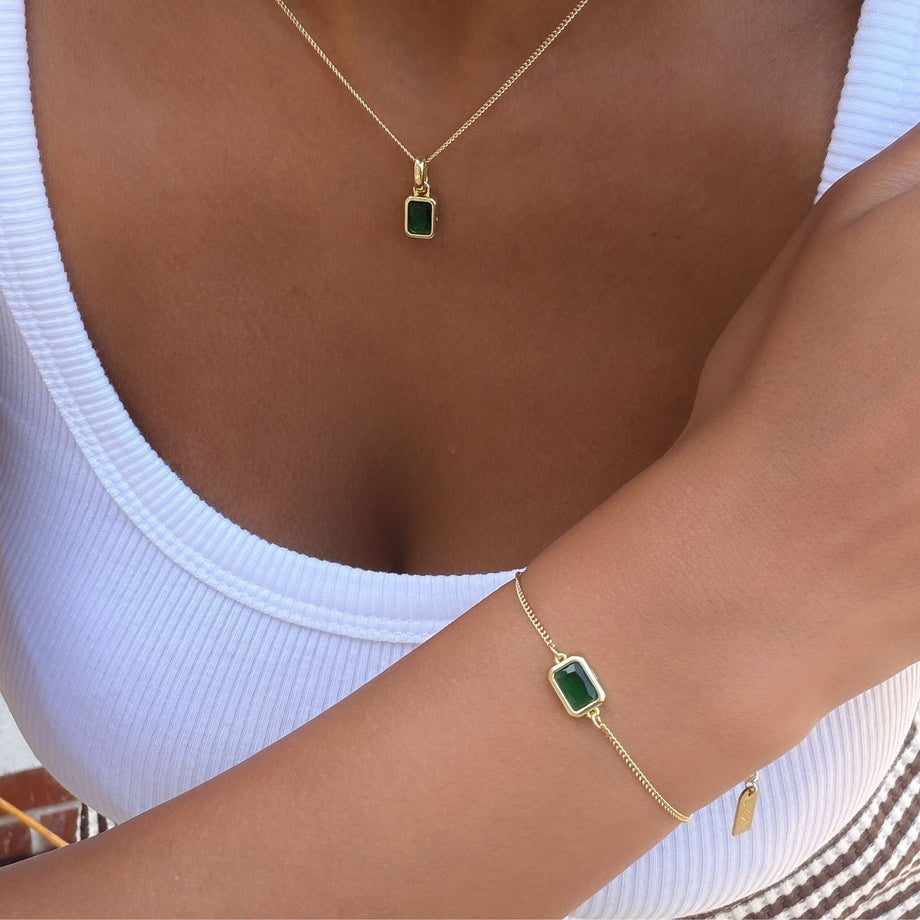 Model wearing the may emerald cut birthstone necklace and bracelet  in gold from prya