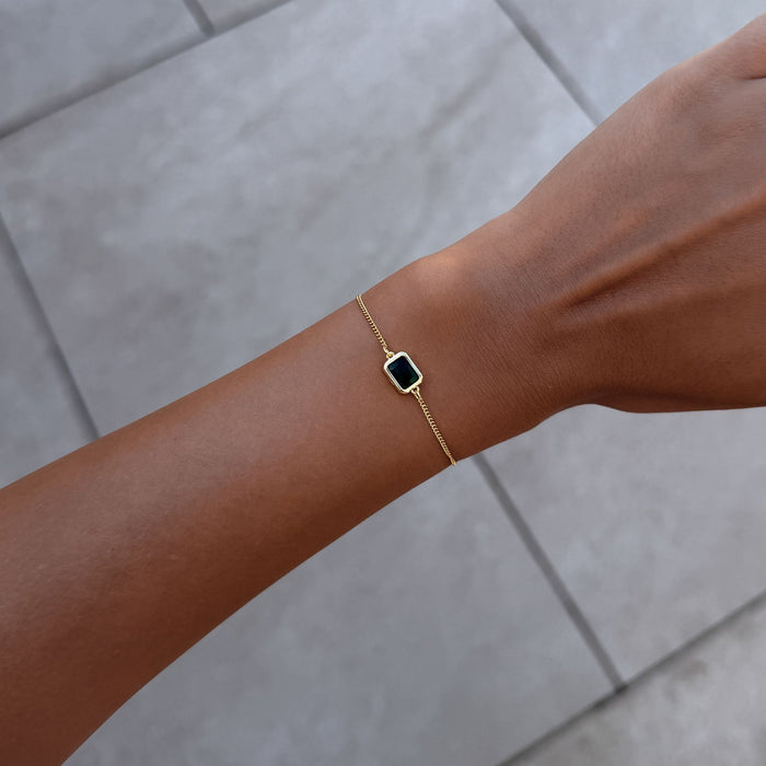 Model wearing the may emerald cut birthstone bracelet  in gold from prya