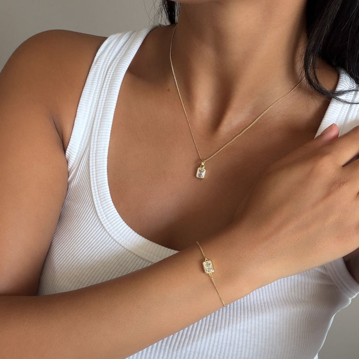 Model wearing the april emerald cut birthstone necklace and bracelet  in gold from prya