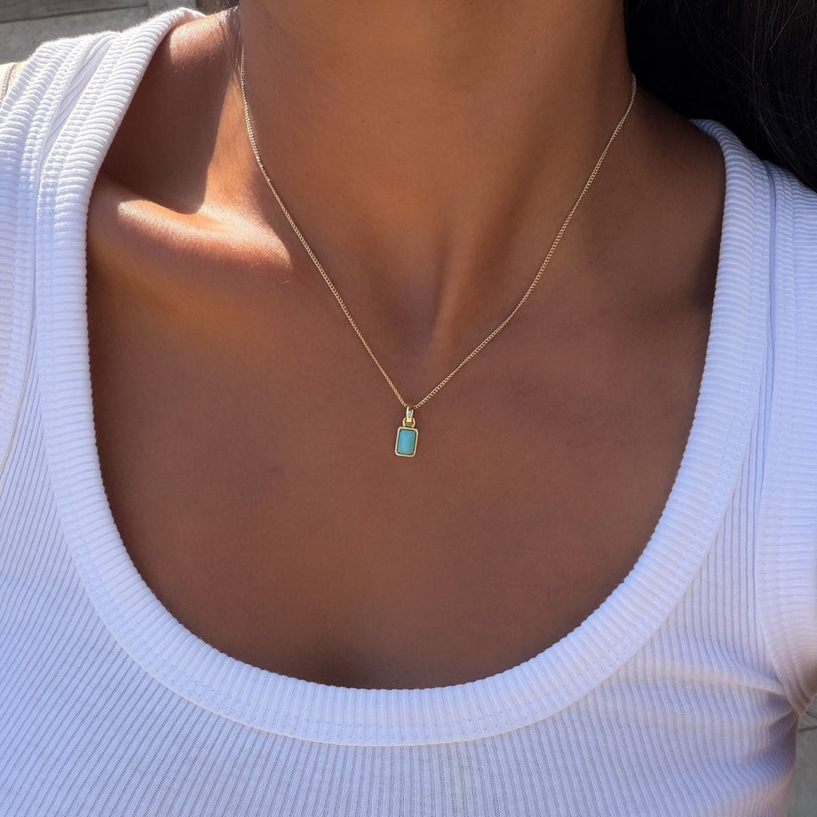 Model wearing the december emerald cut birthstone necklace in gold from prya