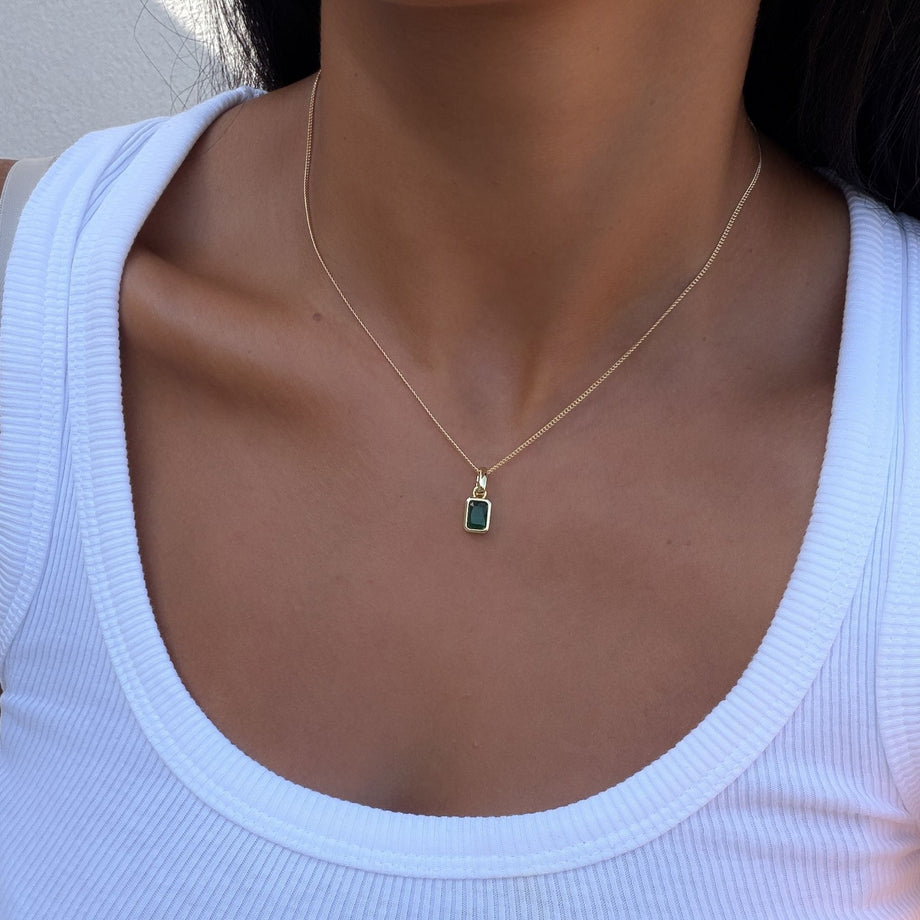 Model wearing the august emerald cut birthstone necklace and bracelet  in gold from prya