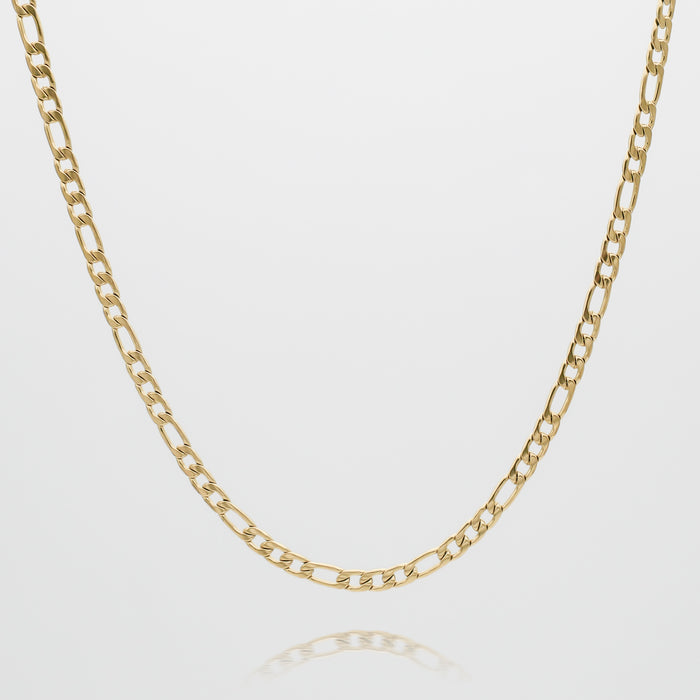 Gold Figaro chain necklace against white background.