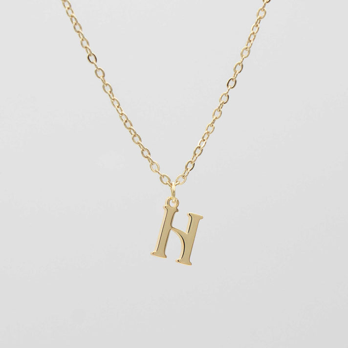 Gold plated initial necklace featuring the letter "H" on a delicate chain, perfect for personalization.