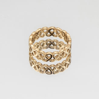 Hallie Ring features a striking gold plated band with a Celtic-inspired design, adorned with a classic love knot from Prya