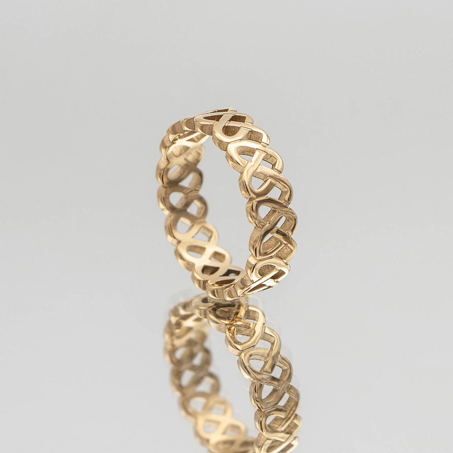 Hallie Ring features a striking gold plated band with a Celtic-inspired design, adorned with a classic love knot from Prya