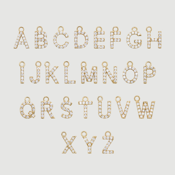 Gold alphabet charms with embedded crystals.