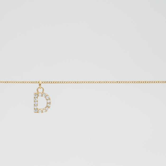 Gold chain with a diamond-studded "D" pendant.