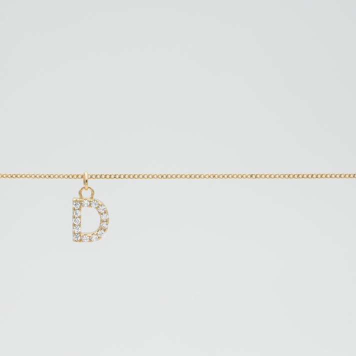 Gold chain with a diamond-studded "D" pendant.