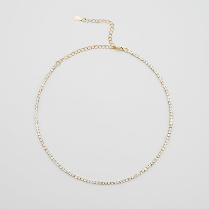 Gold tennis necklace with small diamonds.