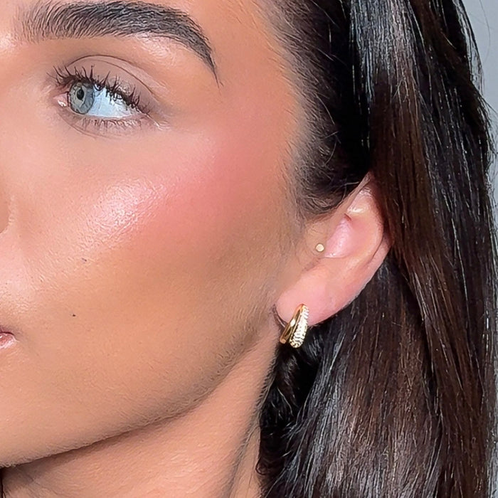 Close-up of a woman wearing gold hoop PRYA earrings 