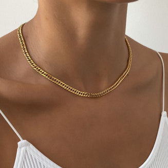 Gold chain necklace on a person's neck.