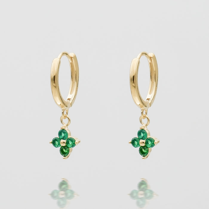 Gold hoop earrings with green gemstone flower charms.