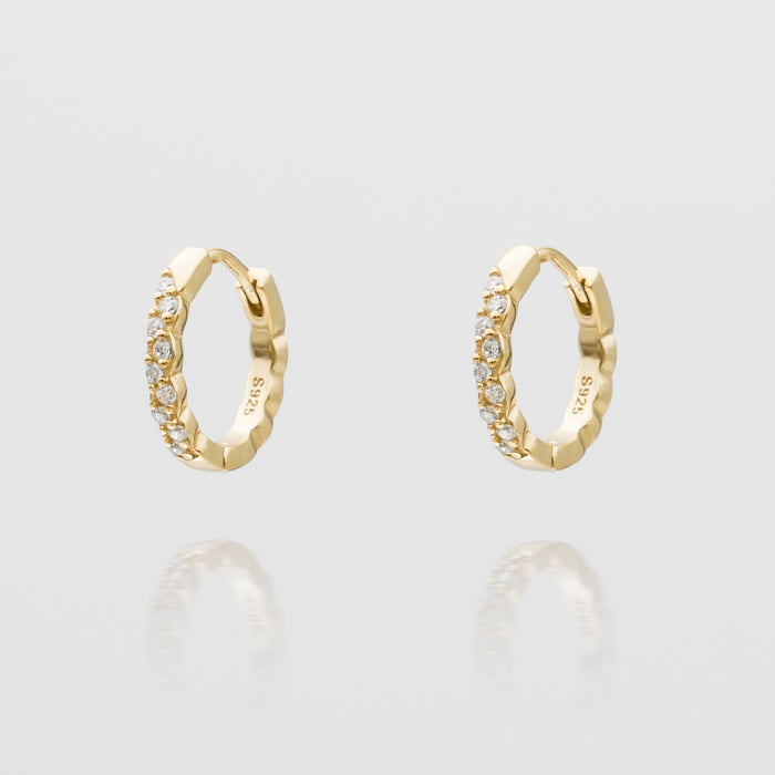 Gold hoop earrings with embedded diamonds.