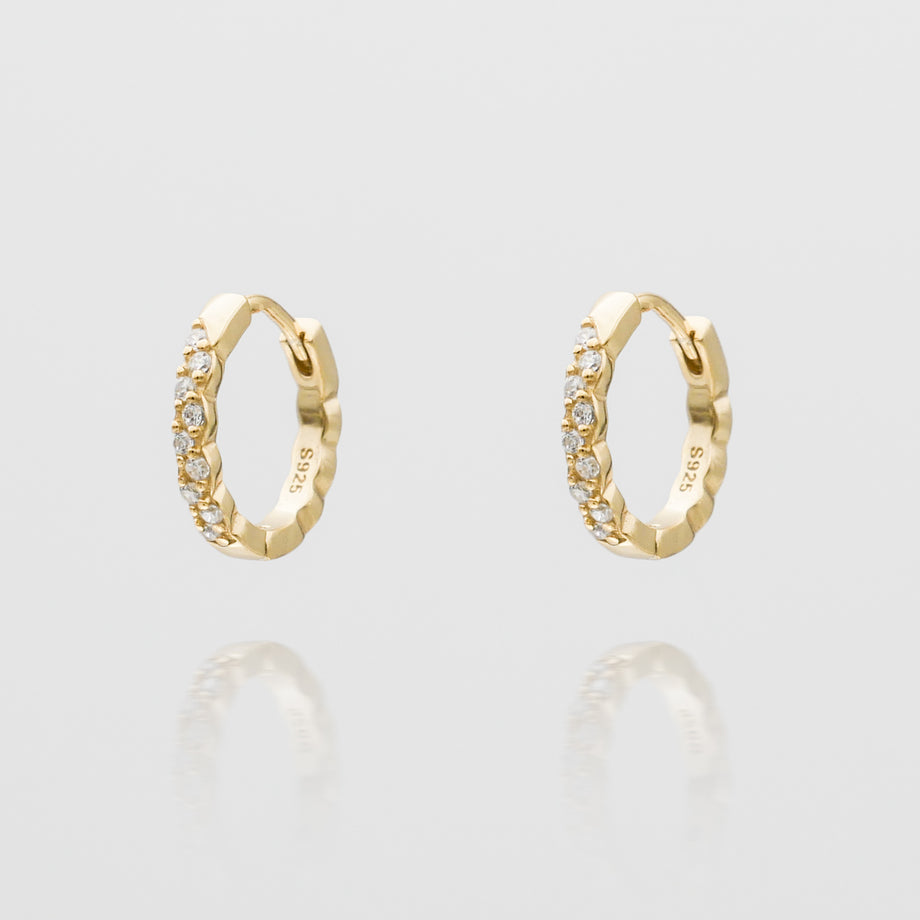 Gold hoop earrings with embedded diamonds.
