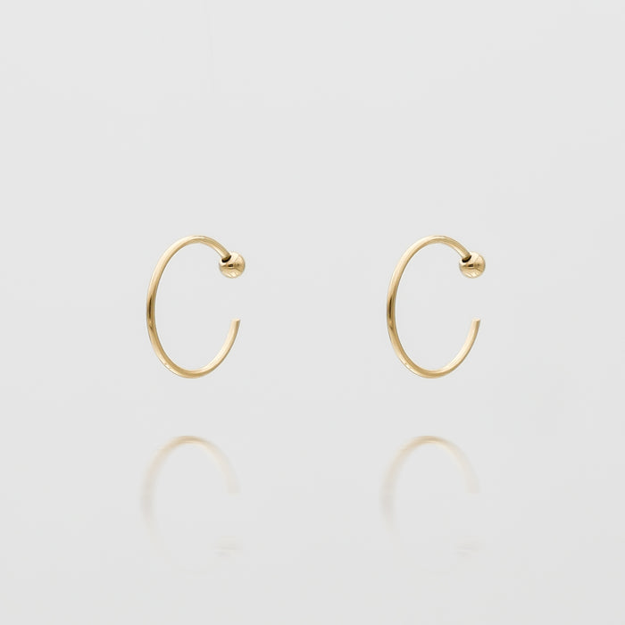 Gold hoop earrings on white background.