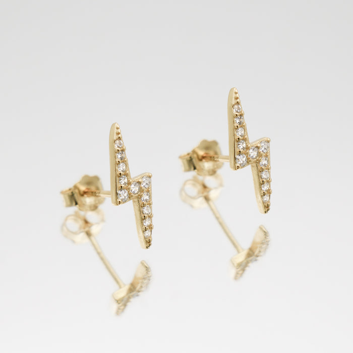 Gold lightning bolt stud earrings with diamonds.