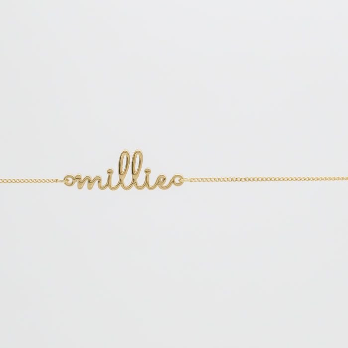 Gold belly chain with "millie" script.