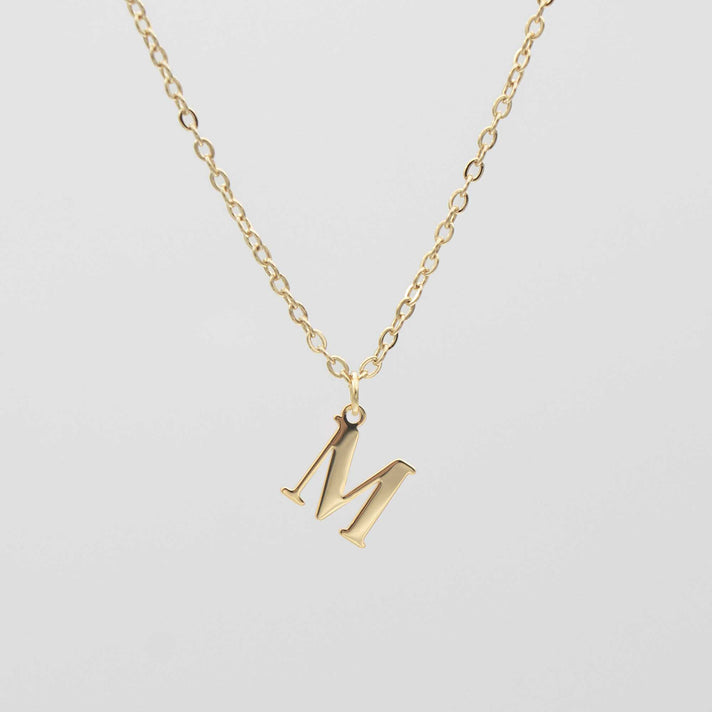 Gold plated initial necklace featuring the letter "M" on a delicate chain, perfect for personalization.