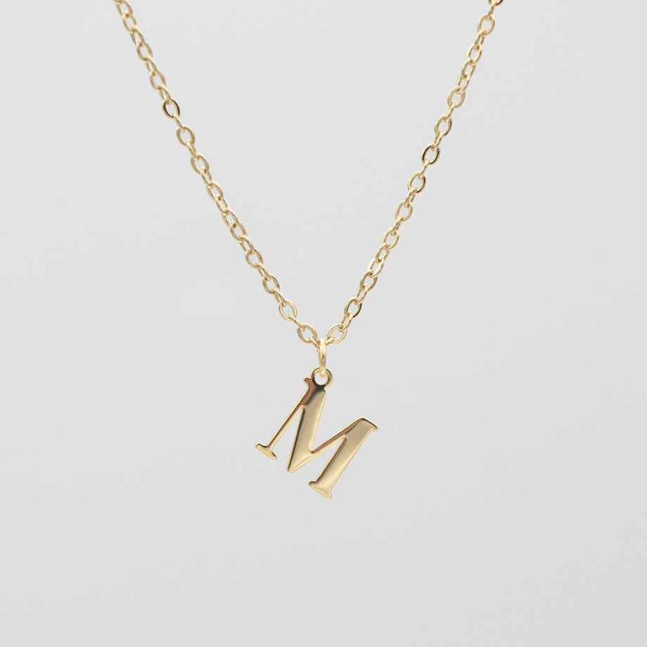 Gold plated initial necklace featuring the letter "M" on a delicate chain, perfect for personalization.