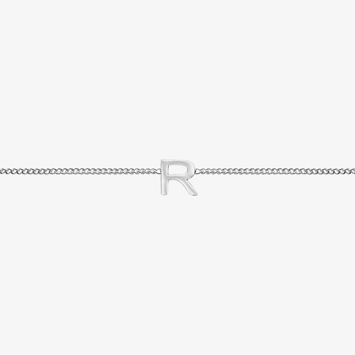 Maia Initial Bracelet with 'R' pendant on a delicate silver chain, perfect accessory for any occasion.