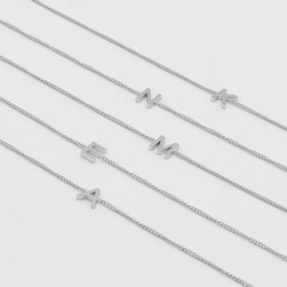 Maia Initial Bracelets featuring gold link chains with letter pendants for personalised elegance.