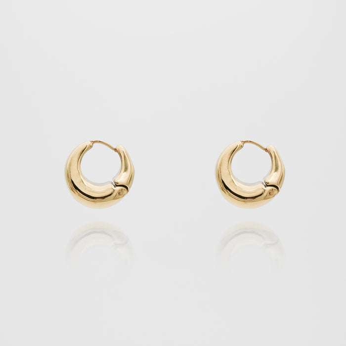 Gold hoop earrings on white background.