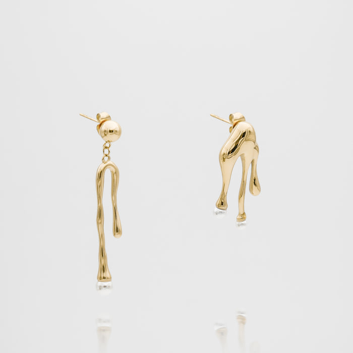 Gold abstract drop earrings on white background.