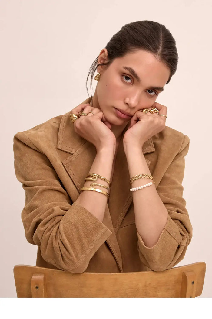 model wearing old bangles and bracelet, stacked rings and earrings from prya