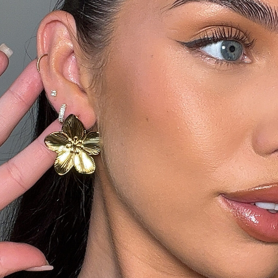 model wears the Naya 18k Gold plated Earrings feature a stunning design inspired by the delicate hibiscus flower from prya