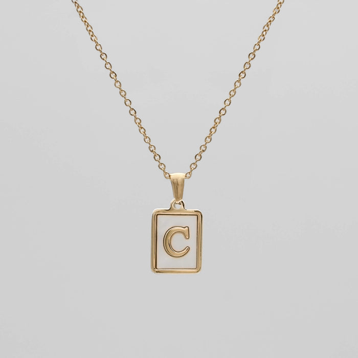 Gold opal necklace with a letter "C" pendant.