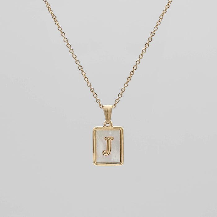 Gold opal necklace with a letter "J" pendant.