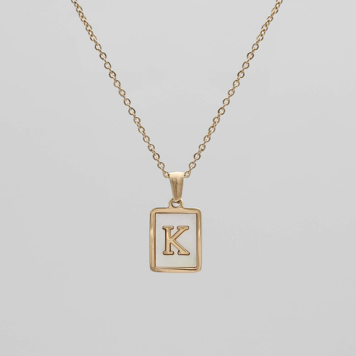 Gold opal necklace with a letter "K" pendant.