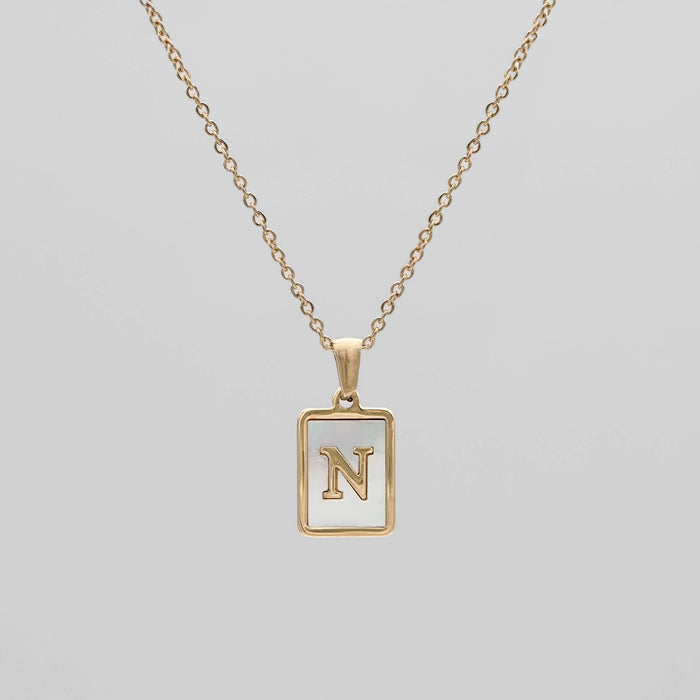 Gold opal necklace with a letter "N" pendant.