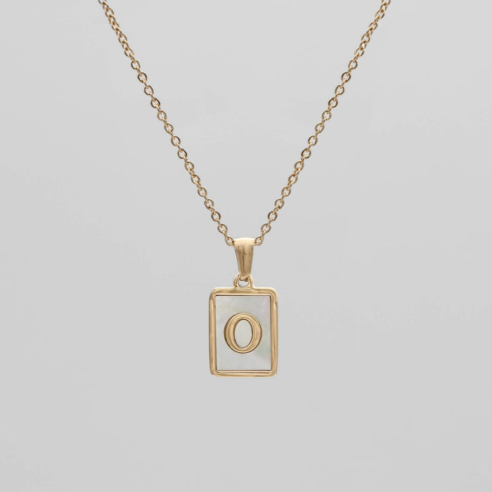 Gold opal necklace with a letter "O" pendant.
