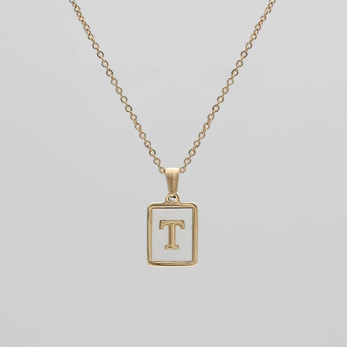 Gold opal necklace with a letter "T" pendant.