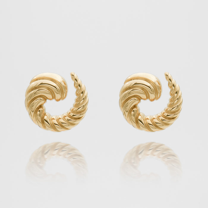 Gold twisted hoop earrings on white background.