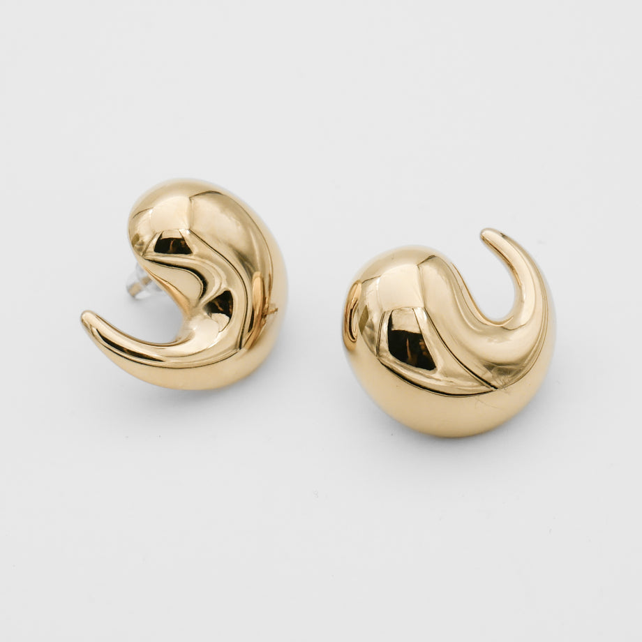Gold abstract swirl earrings on white background.