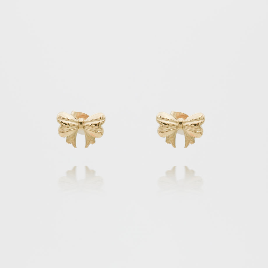 Gold bow-shaped stud earrings on white background.