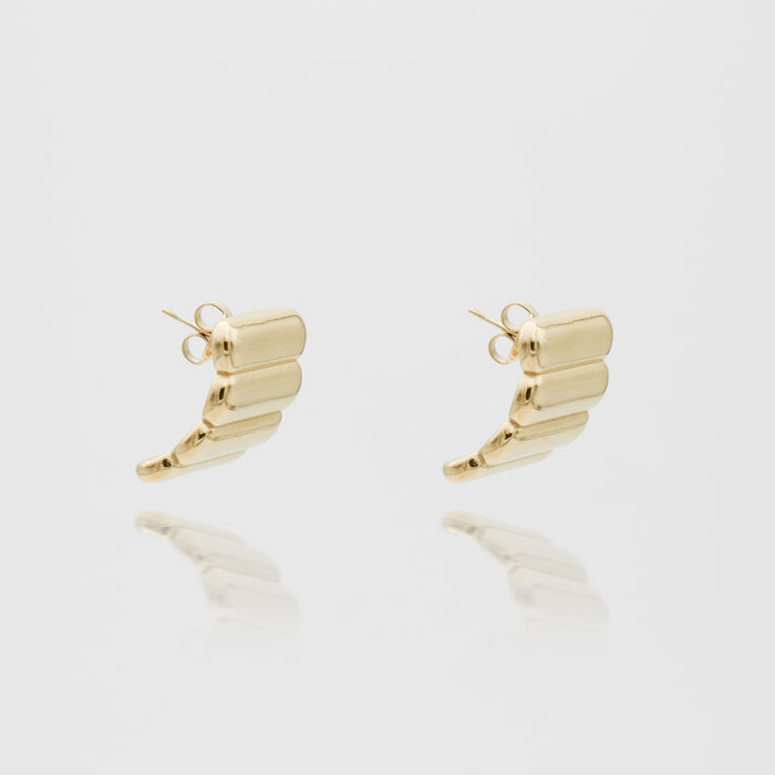 Gold ribbed hoop earrings on white background.