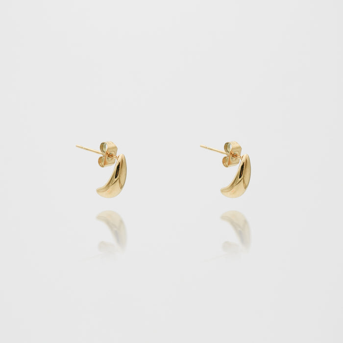 Gold crescent earrings on white background.