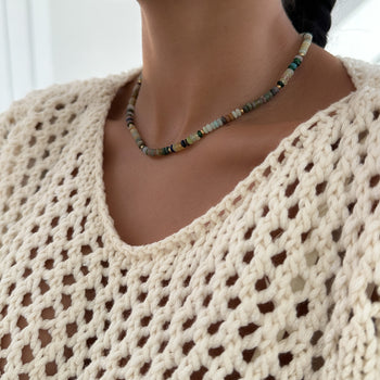  model wearing Ren Natural Stone Beaded Necklace, in earthy or water tones, accented by lustrous gold plated beads. 