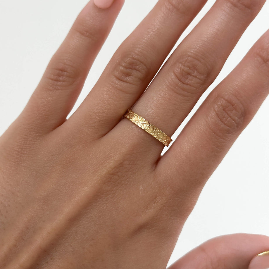 model wearing Aurora Ring is a dainty Gold plated ring featuring intricate heart geometric patterns inspired by Celtic designs