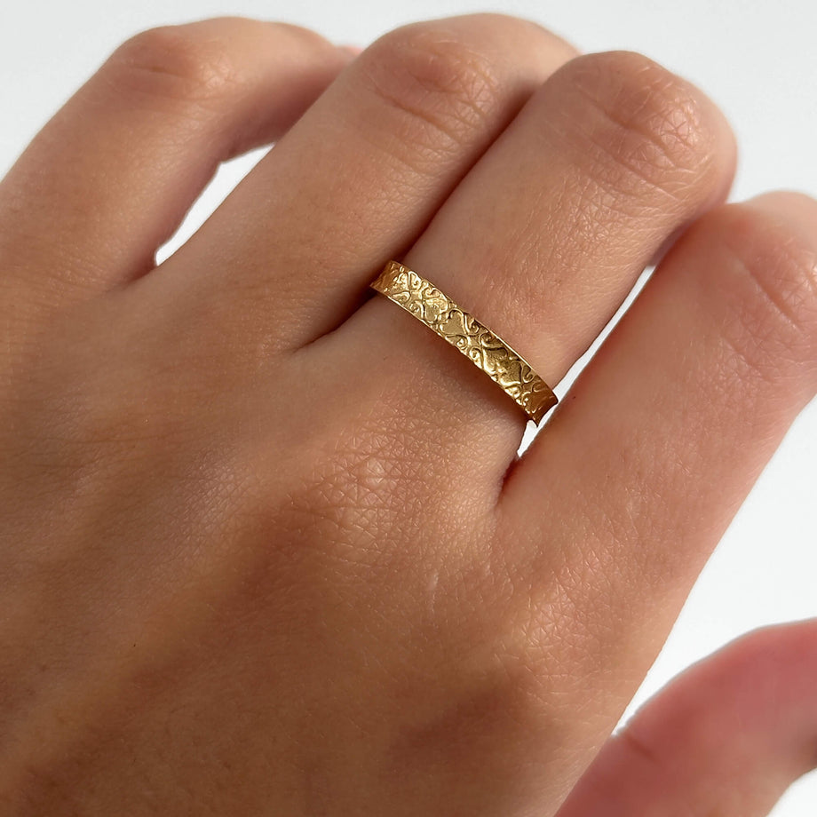 model wearing Aurora Ring is a dainty Gold plated ring featuring intricate heart geometric patterns inspired by Celtic designs